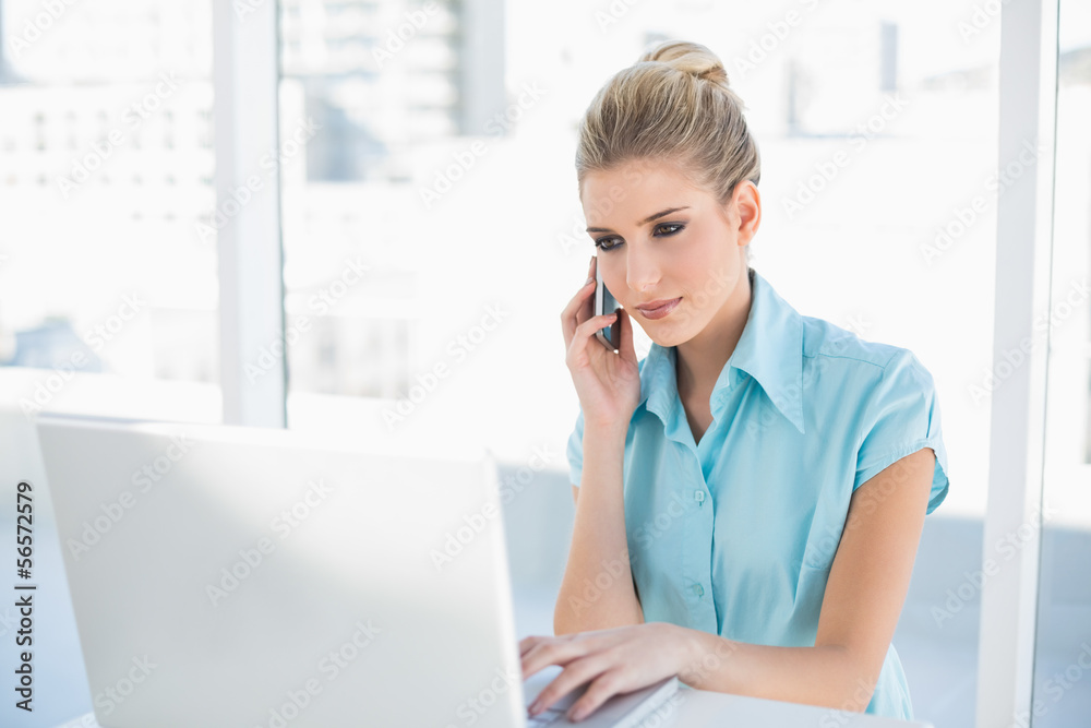 Relaxed smart businesswoman on the phone while using laptop Relaxed smart businesswoman on the phone while using laptop