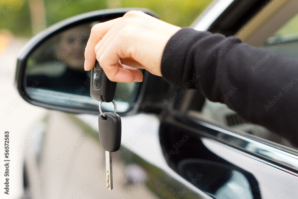 Woman holding the ignition keys of a car Woman holding the ignition keys of a car