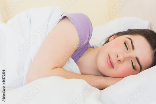 Cheerful girl sleeping in her bed