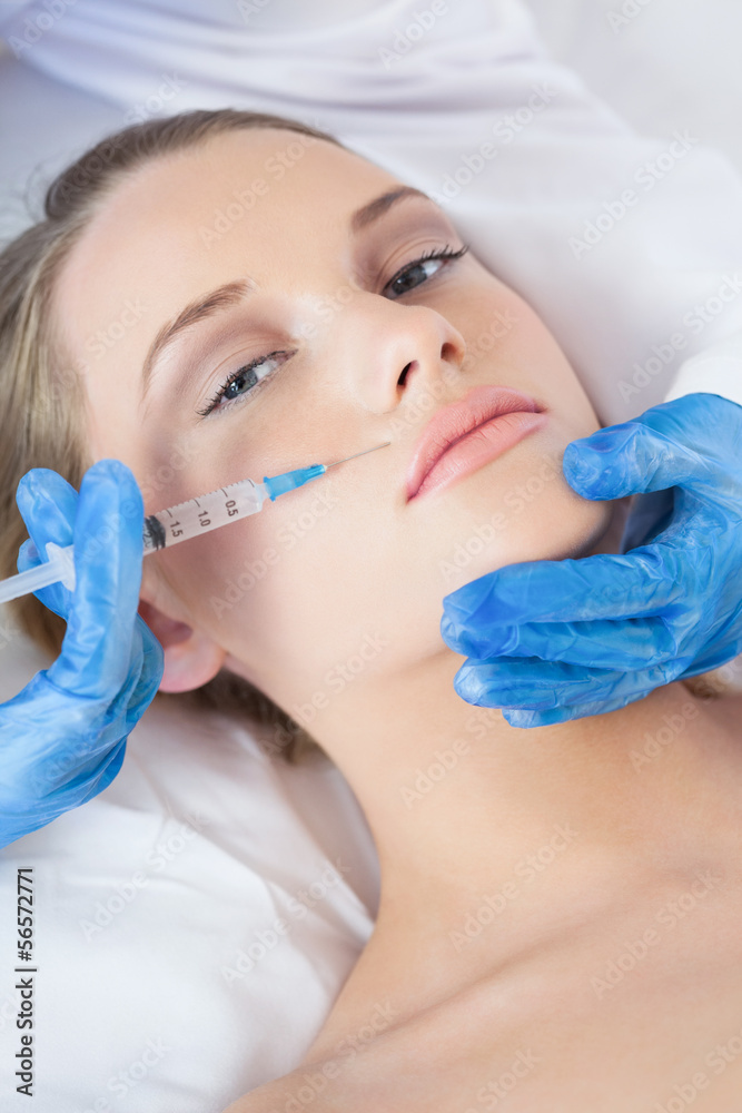 Surgeon making injection above lips on pretty woman lying Surgeon making injection above lips on pretty woman lying