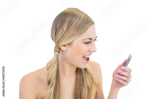 Angry young blonde woman yelling at her mobile phone
