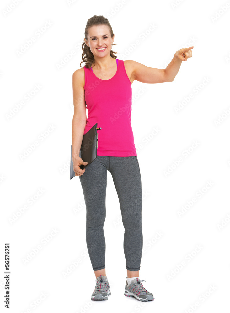 Full length portrait of smiling fitness trainer with clipboard Full length portrait of smiling fitness trainer with clipboard