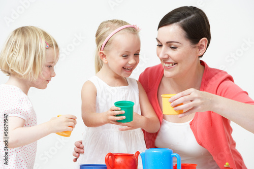 Pre School Children Enjoying Tea Party With Teacher