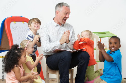 Pre School Teacher Reading Story To Children And Praying photo