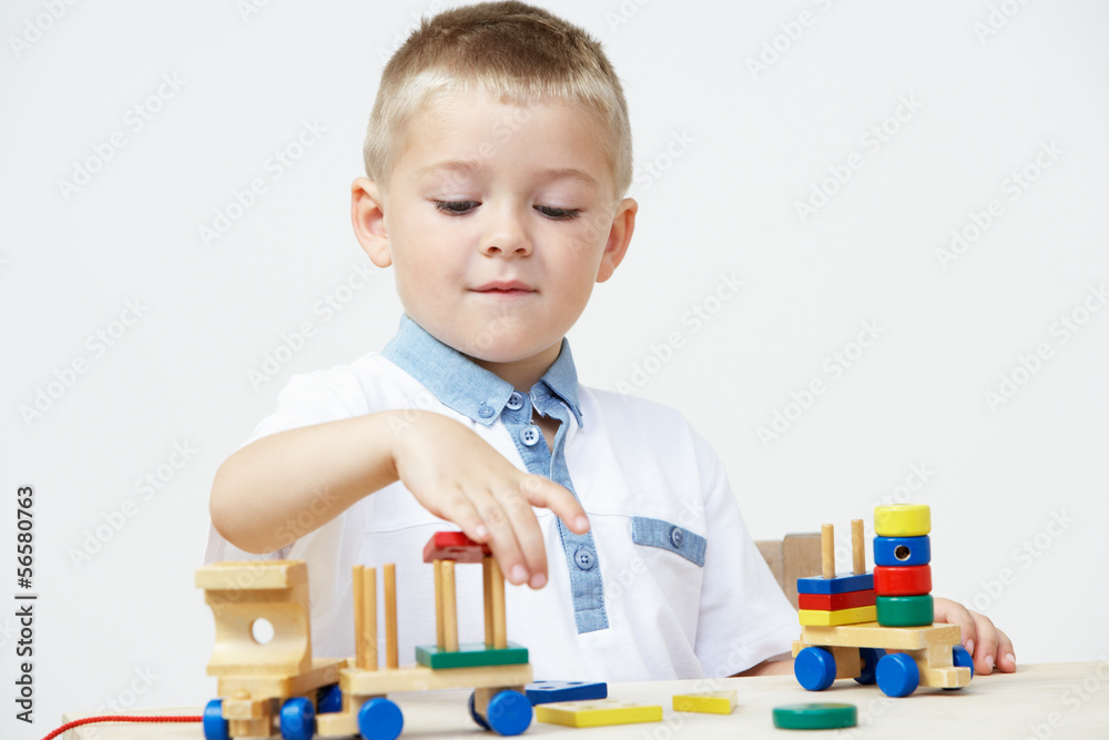 Pre-School Pupil Playing With Wooden Toy Train