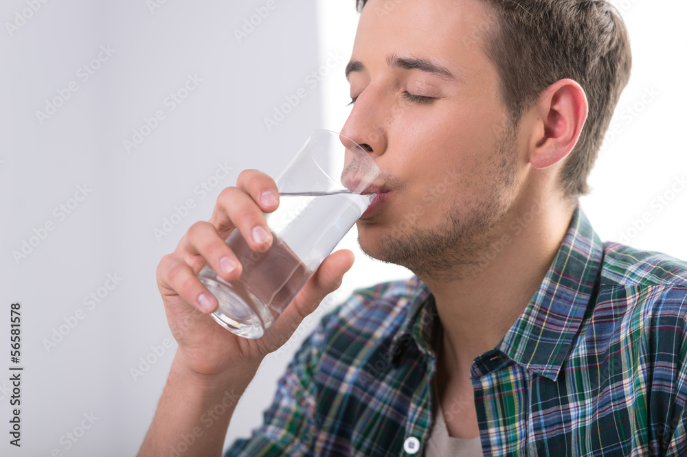 Man drinking water. Handsome young men drinking water and keepin Man drinking water. Handsome young men drinking water and keepin