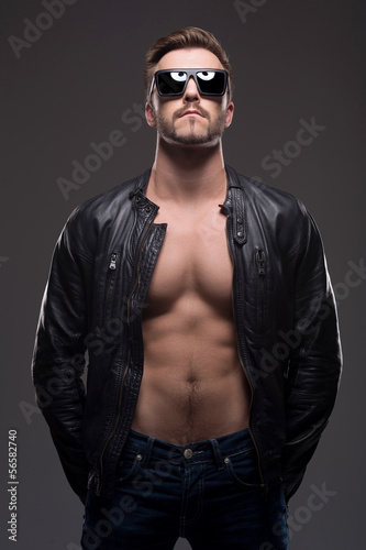 Stylish man. Handsome young man in leather coat and sunglasses s © BlueSkyImages