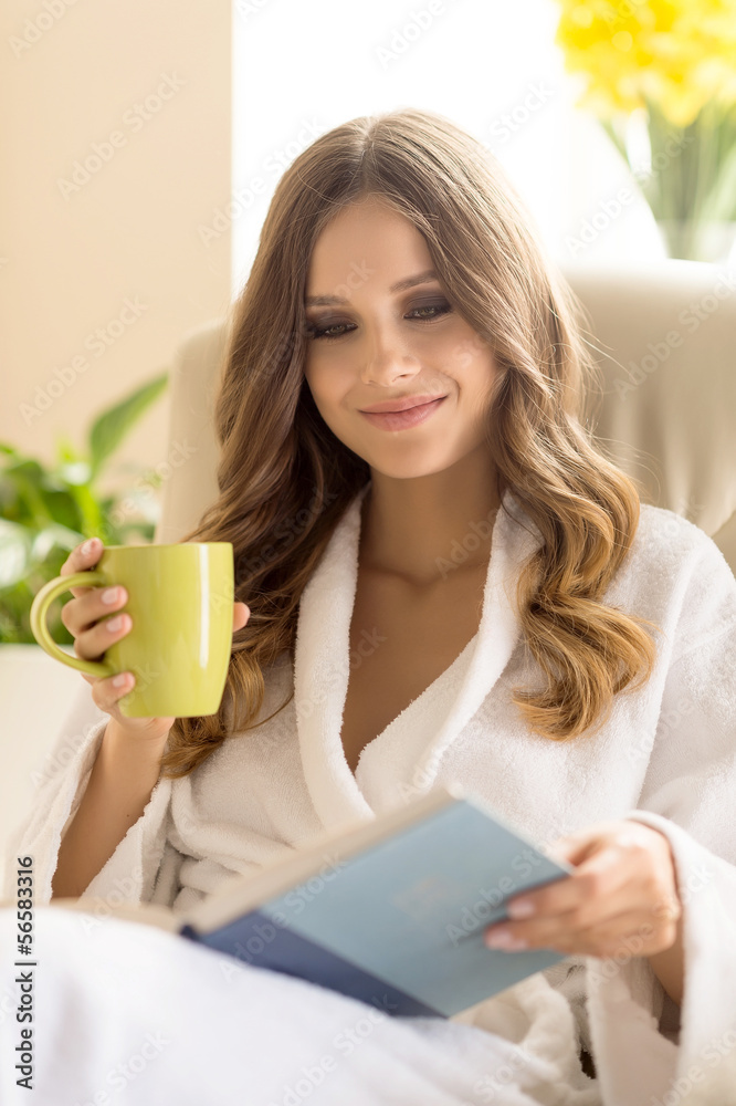 Day off at home. Beautiful young woman in bathrobe drinking coff Day off at home. Beautiful young woman in bathrobe drinking coff