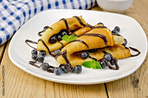 Pancakes with blueberries and chocolate syrup