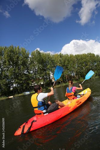 Couple riding canoe in river © goodluz