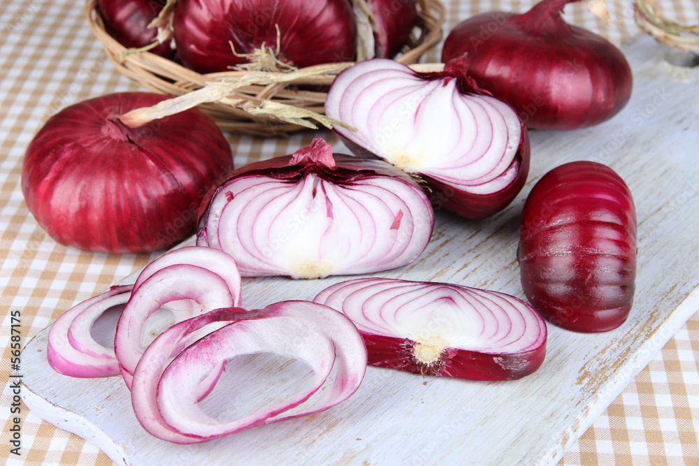 Fresh red onions on cutting board close up