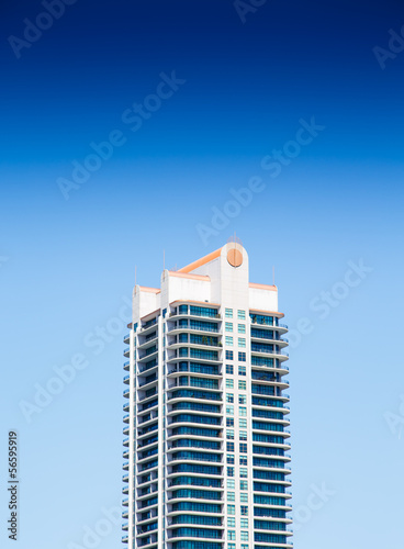 Modern Condo Tower with Balconies Under Blue Skies