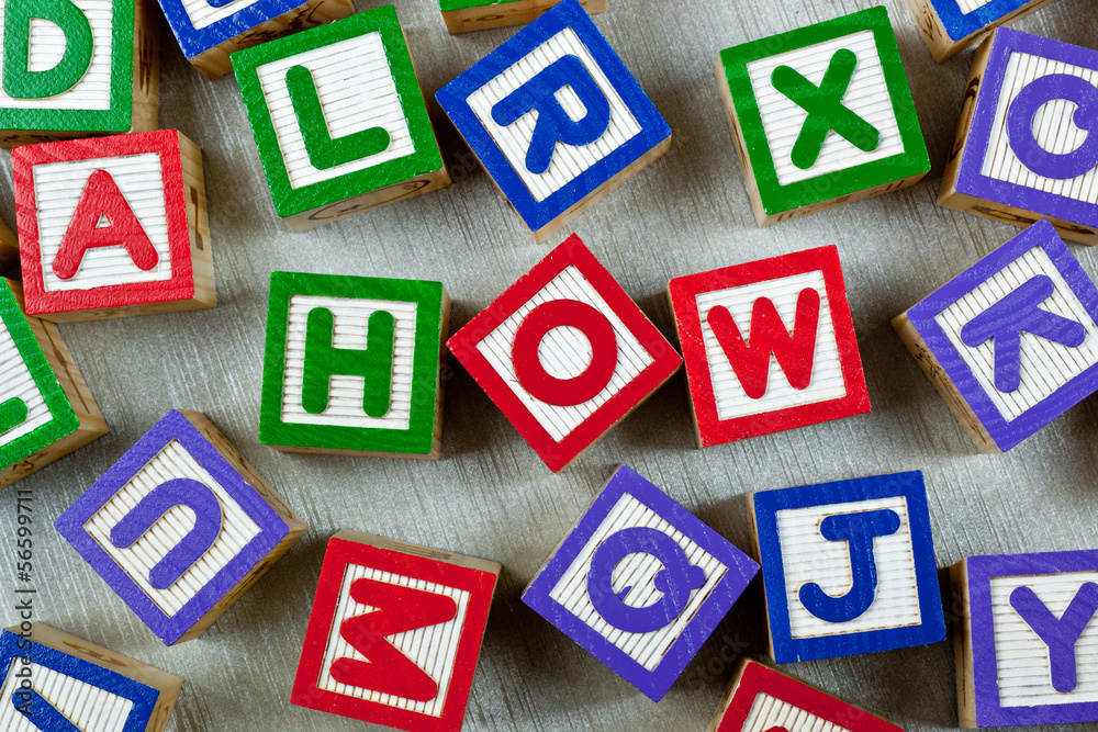 Wooden blocks forming the word HOW in the center Wooden blocks forming the word HOW in the center