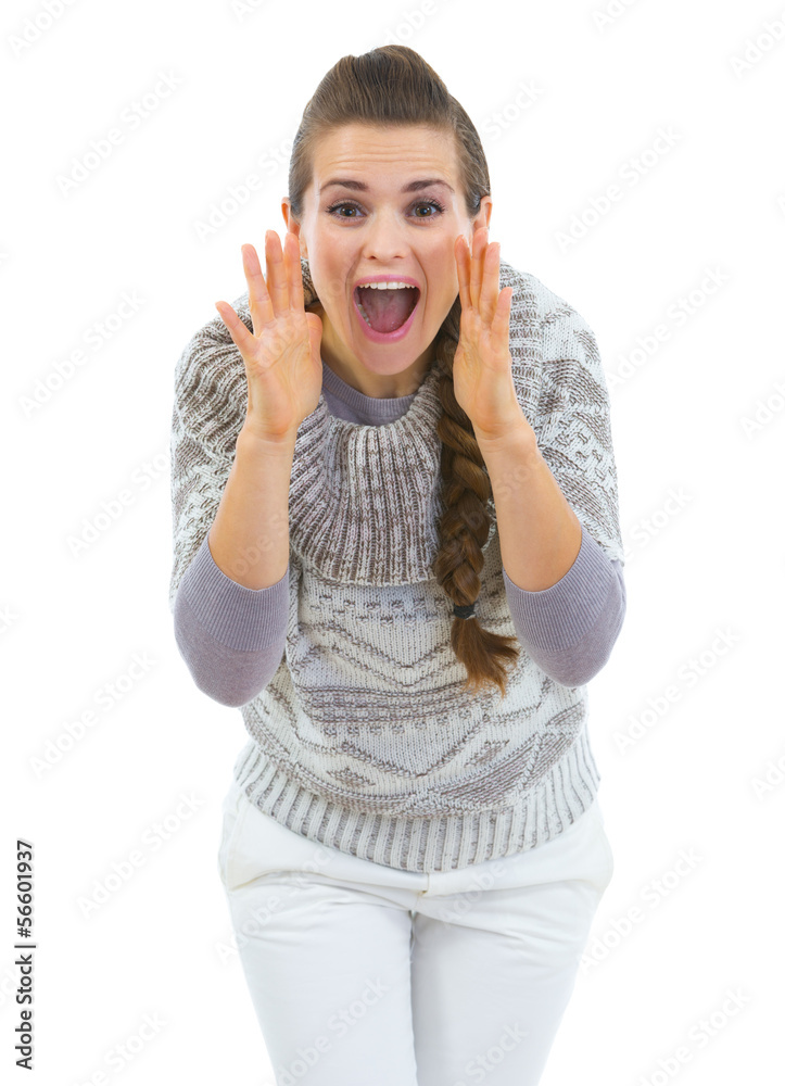 Young woman in sweater shouting through megaphone shaped hands Young woman in sweater shouting through megaphone shaped hands