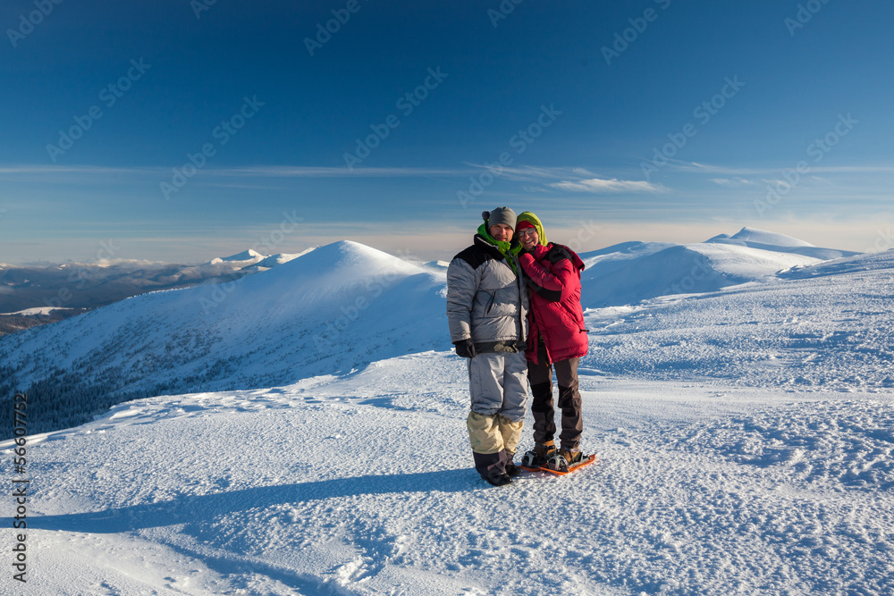 Two hikers posing at camera in winter mountains Two hikers posing at camera in winter mountains