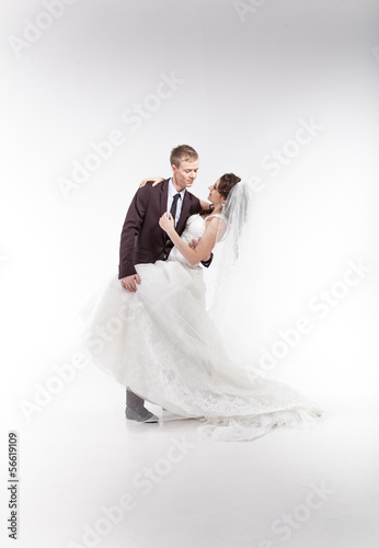 Young newly married couple hugging in studio