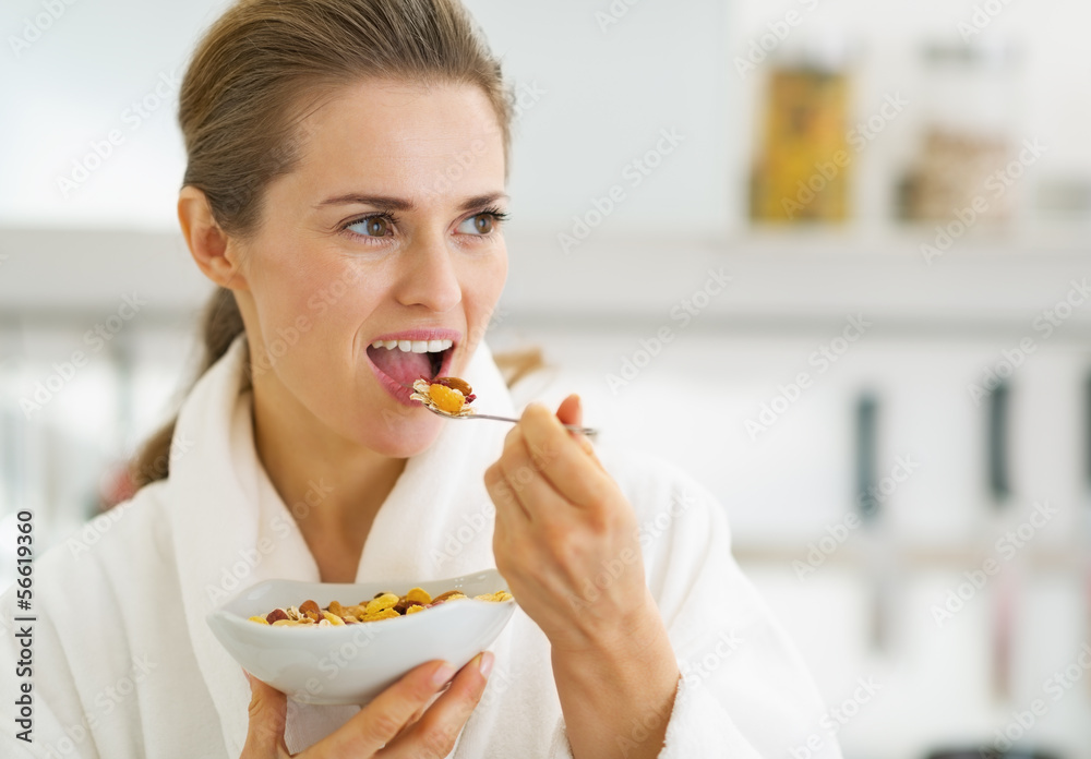 Young housewife in bathrobe having healthy breakfast in kitchen Young housewife in bathrobe having healthy breakfast in kitchen