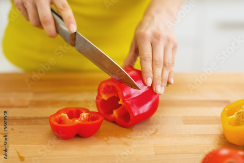 Closeup on woman cutting red bell pepper
