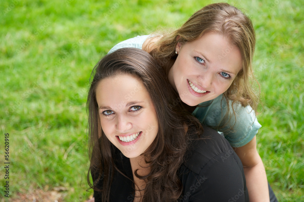 Closeup portrait of two beautiful girls smiling outdoors Closeup portrait of two beautiful girls smiling outdoors