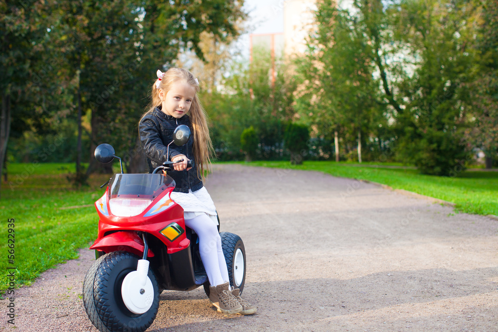 Little beautiful rock girl in leather jacket sitting on her toy Little beautiful rock girl in leather jacket sitting on her toy