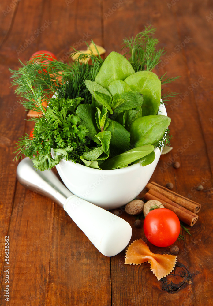 Herbs and spices in ceramic mortar, on wooden background Herbs and spices in ceramic mortar, on wooden background