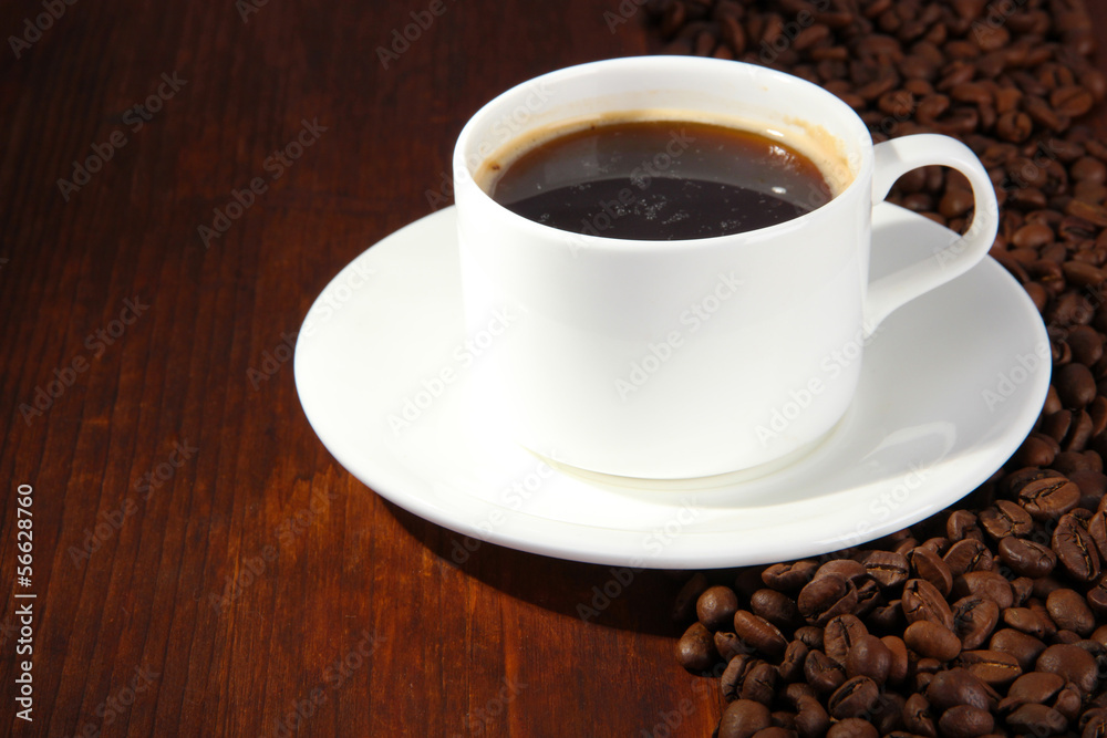 Cup of coffee with coffee beans on wooden background