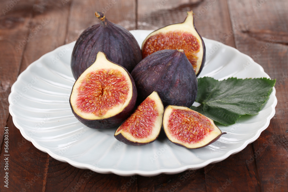 Ripe figs on plate wooden table close-up Ripe figs on plate wooden table close-up
