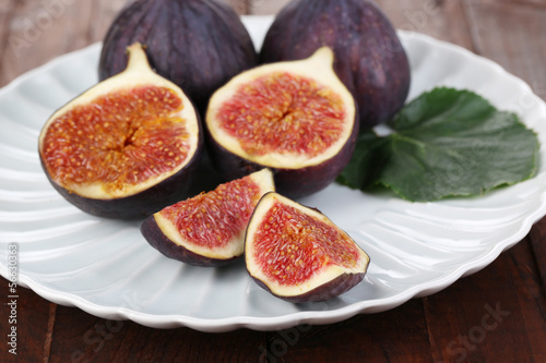 Ripe figs on plate wooden table close-up