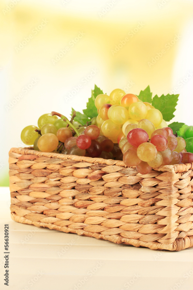 Ripe sweet grape in basket on wooden table, on nature