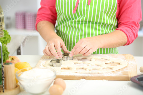 Woman in kitchen during cooking biscuits, close up