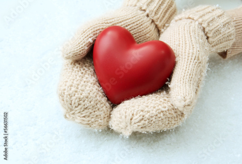 Female hands in mittens with red heart  close-up