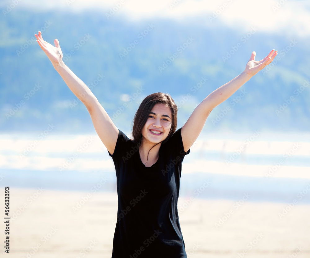 Happy young woman on beach, arms outstretched Happy young woman on beach, arms outstretched