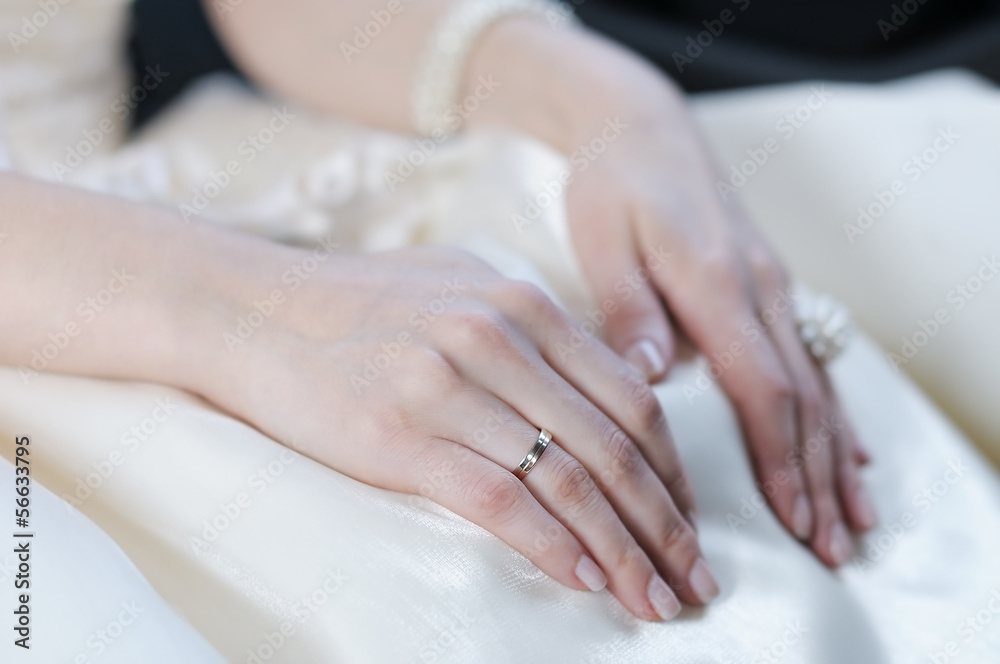 Bride's hand laying on a white dress Bride's hand laying on a white dress