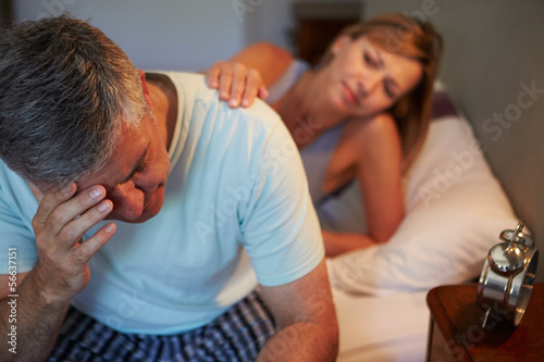 Wife Comforting Husband Suffering With Insomnia