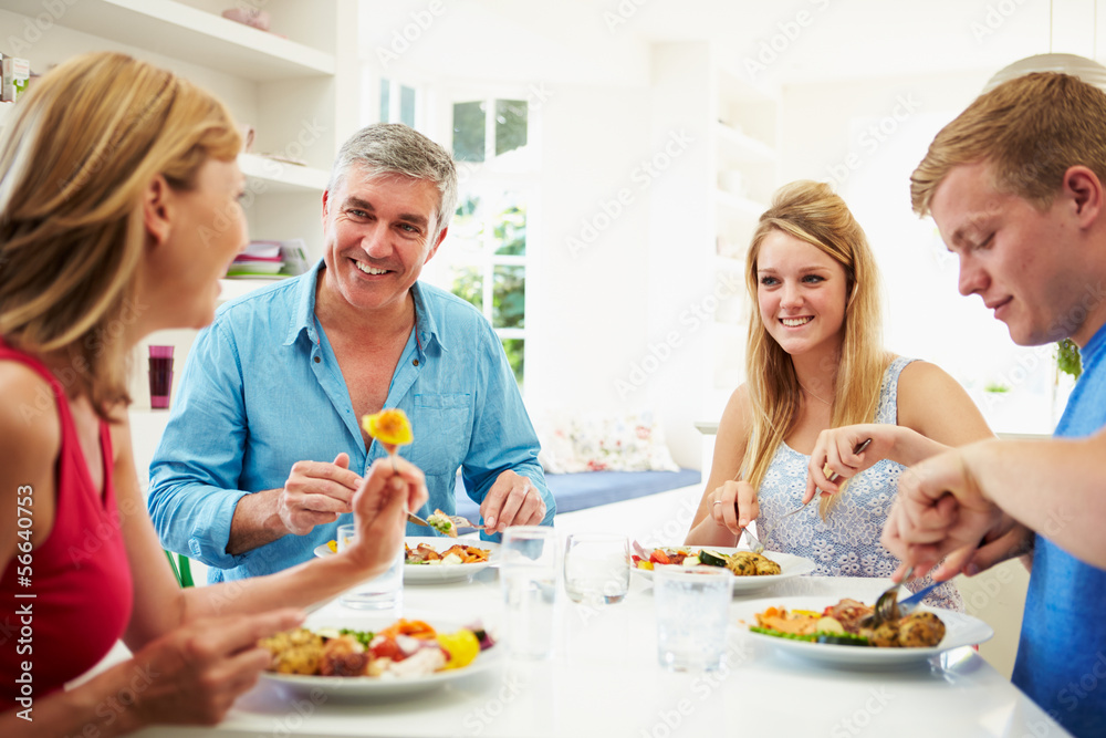 Family With Teenage Children Eating Meal At Home Together