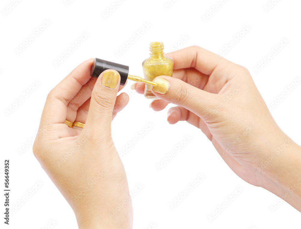 female hand with a golden nail polish on white background female hand with a golden nail polish on white background