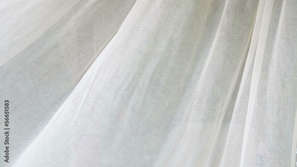 Sheer white curtains blowing in the wind