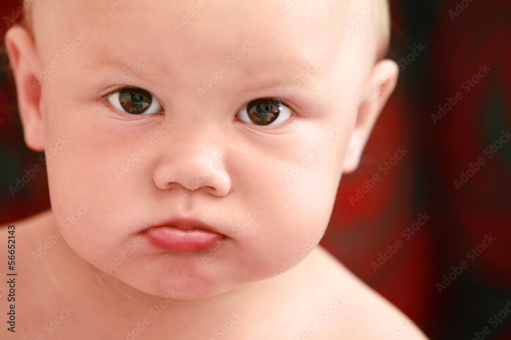 Serious Caucasian baby girl close-up portrait
