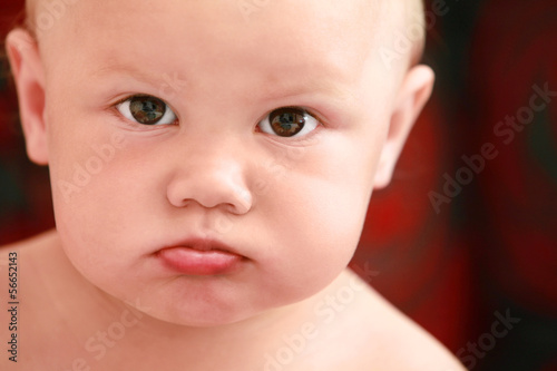 Serious Caucasian baby girl close-up portrait