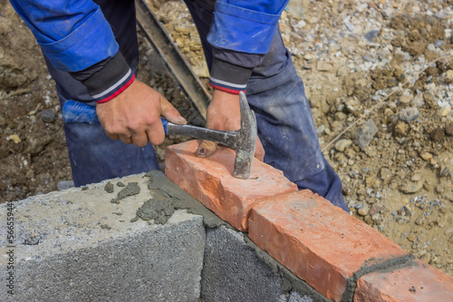 Man laying concrete block and bricks wall