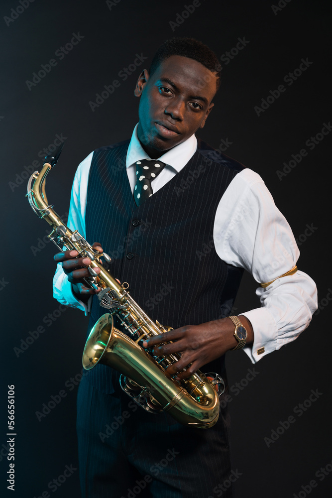Fototapeta premium Retro african american jazz musician holding his saxophone. Wear