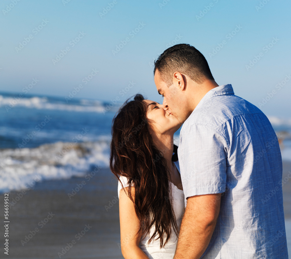 romantic couple kissing each other on the beach.