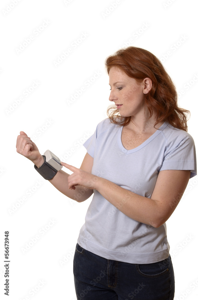 Hübsche rothaarige Frau mit Blutdruckmessgerät Hübsche rothaarige Frau mit Blutdruckmessgerät
