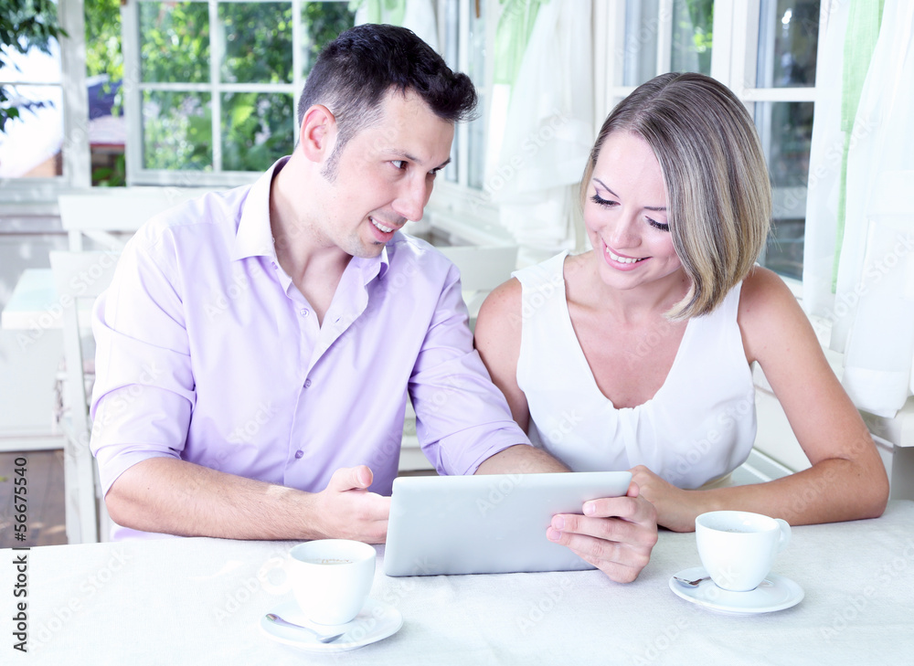 Young couple taking photo with tablet in restaurant Young couple taking photo with tablet in restaurant