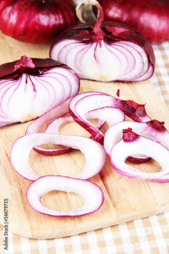 Fresh red onions on cutting board close up