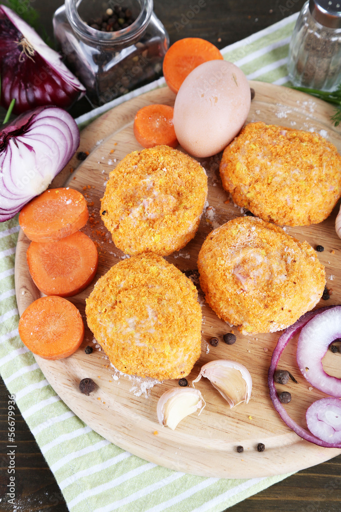 Meat patties on board on napkin on wooden table Meat patties on board on napkin on wooden table