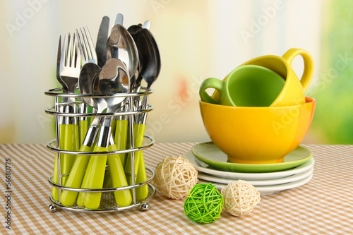 Kitchen cutlery in metal stand with clean dishes