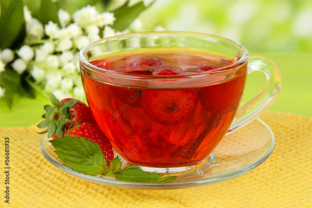 Delicious strawberry tea on table on bright background Delicious strawberry tea on table on bright background