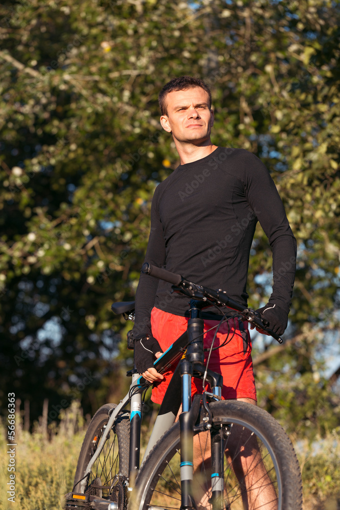Naklejka premium The guy with the bike in the early morning
