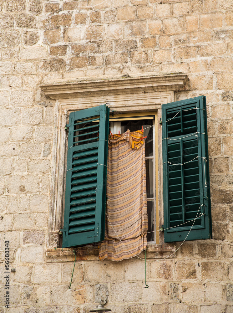 Green Shutters on Old Stone Wall with Laundry